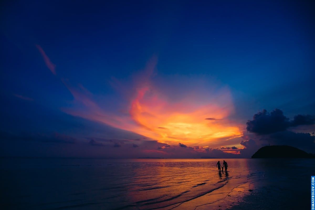 Dreamy family photo at sunset — walking on reflective water during golden hour