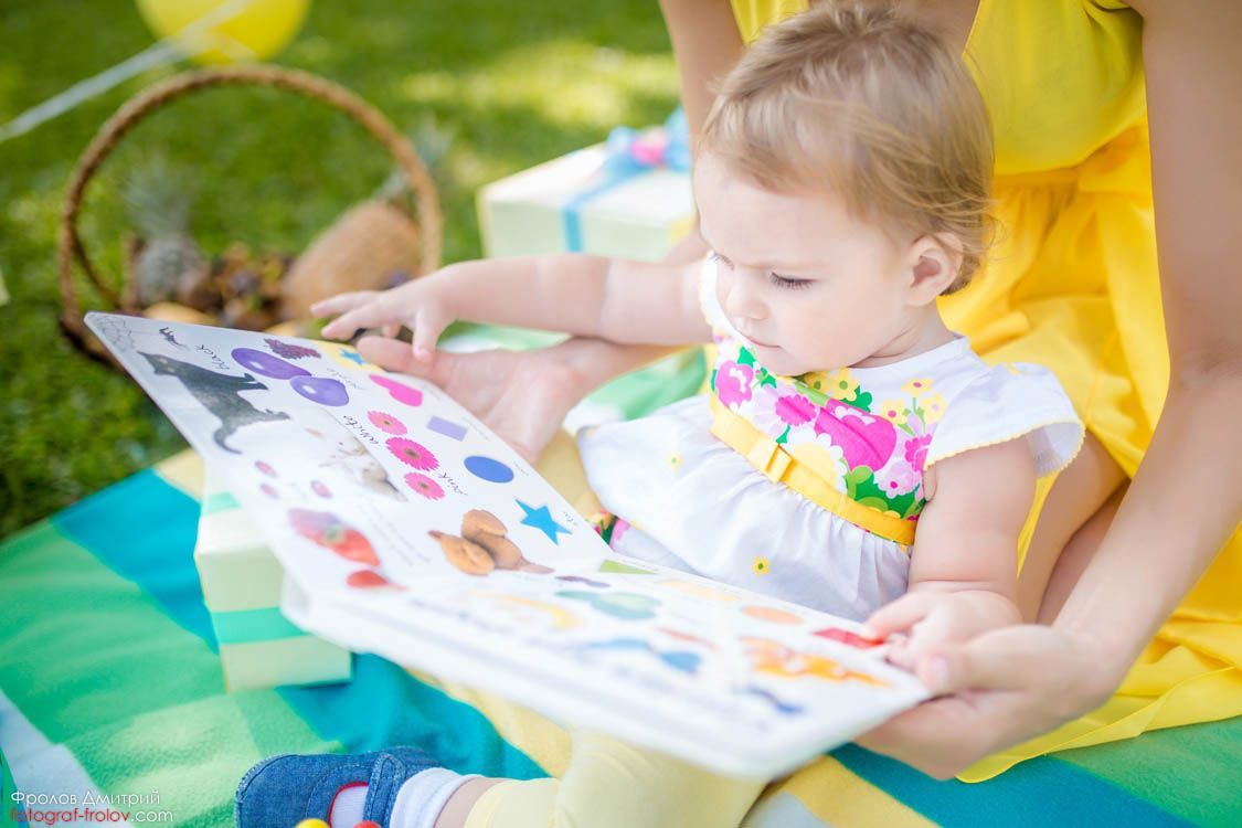 Outdoor family photo — reading time on a blanket in the garden