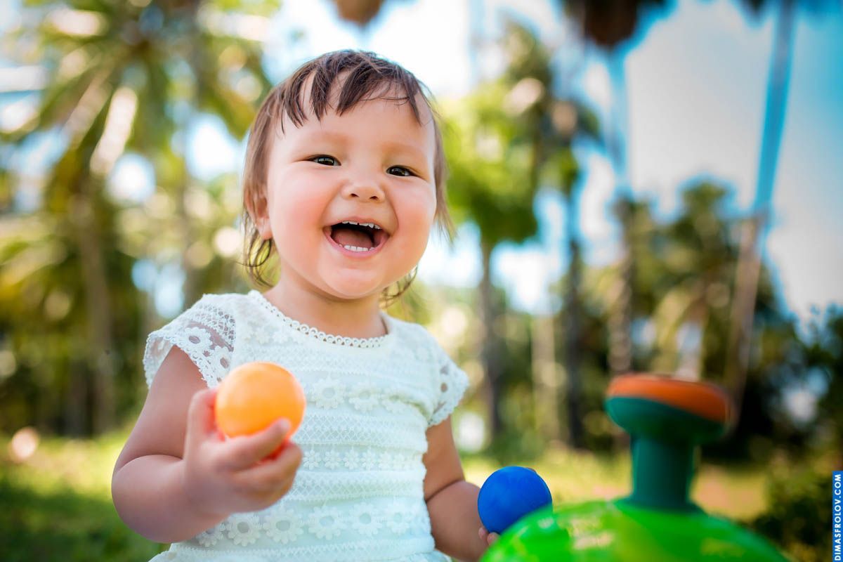 Bright toddler portrait — joyful smile with an orange in hand