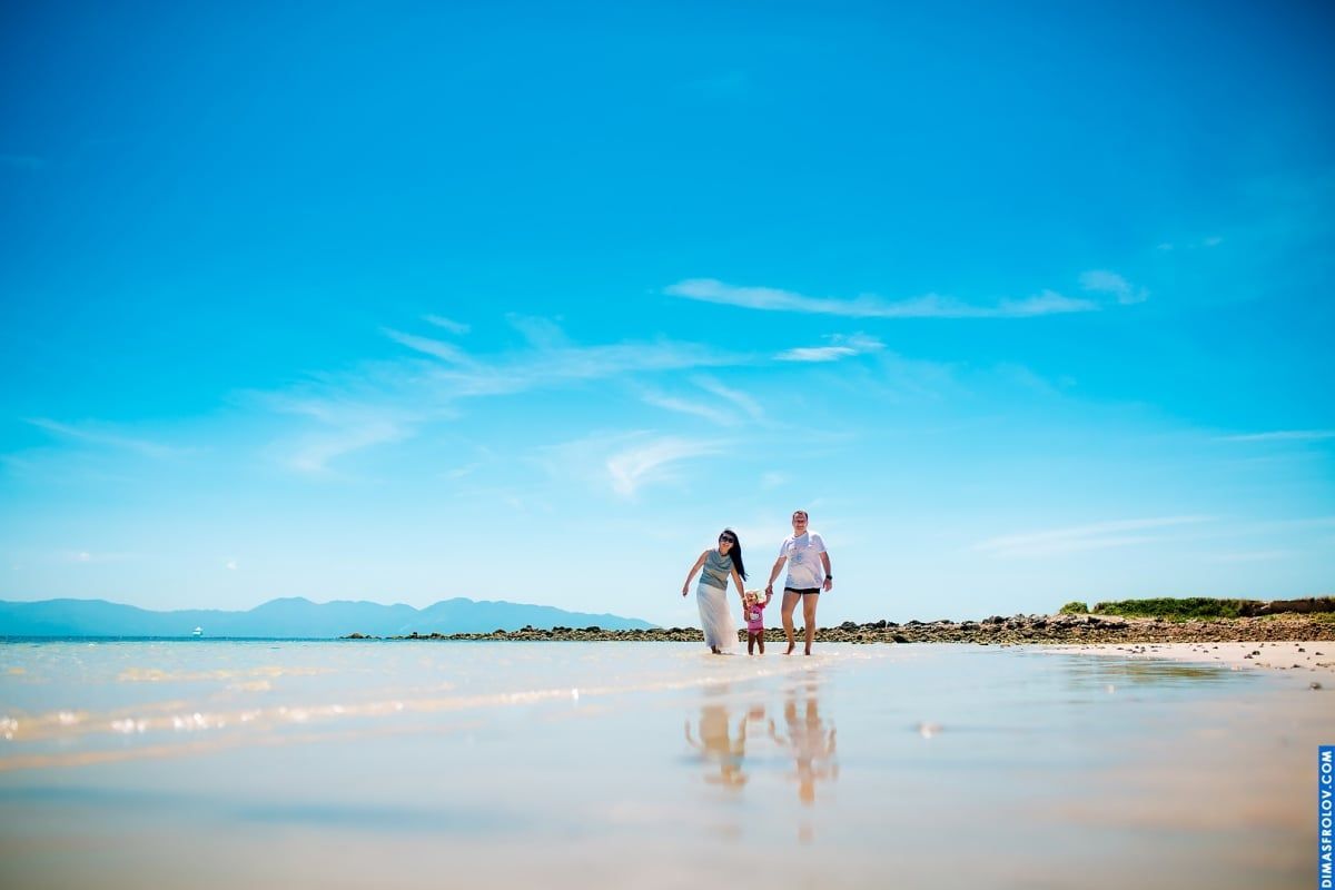 ifestyle photo session of young family walking in shallow water — peaceful and tender portrait