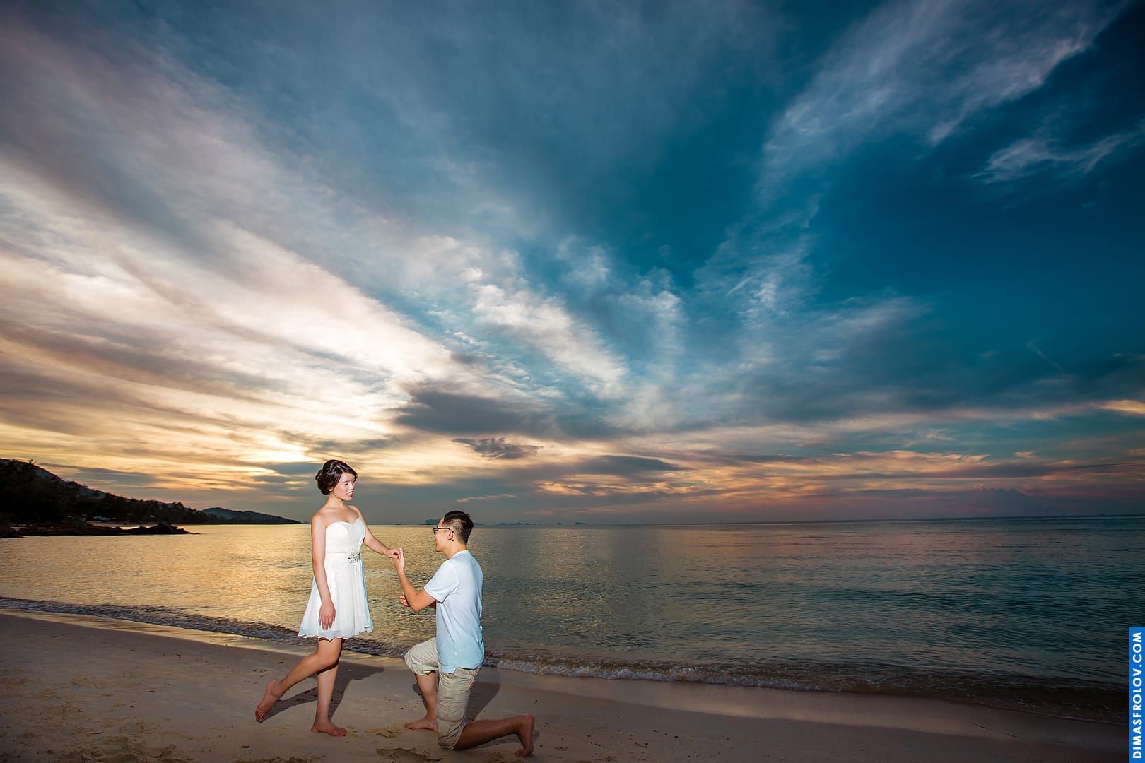 Couple beach walk photo with dramatic sunset sky