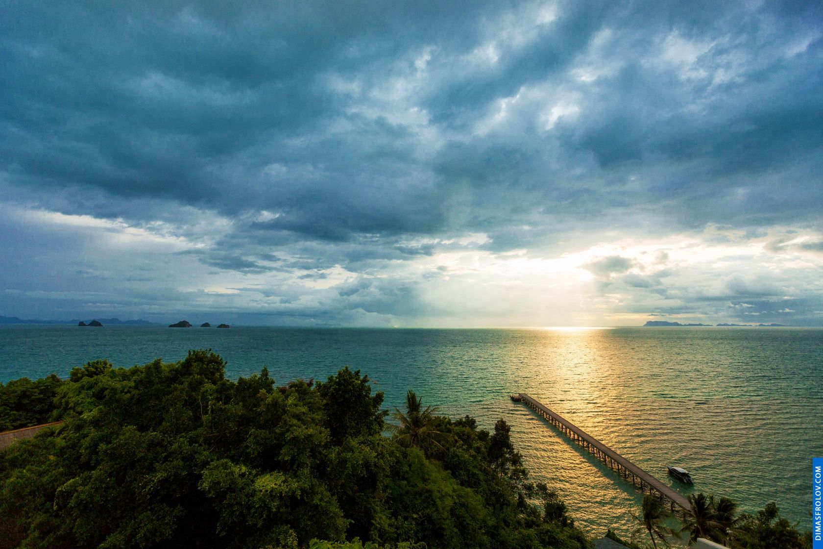 Cena costeira dramática com nuvens escuras e sombrias sobre o oceano e um toque de luz do sol surgindo.