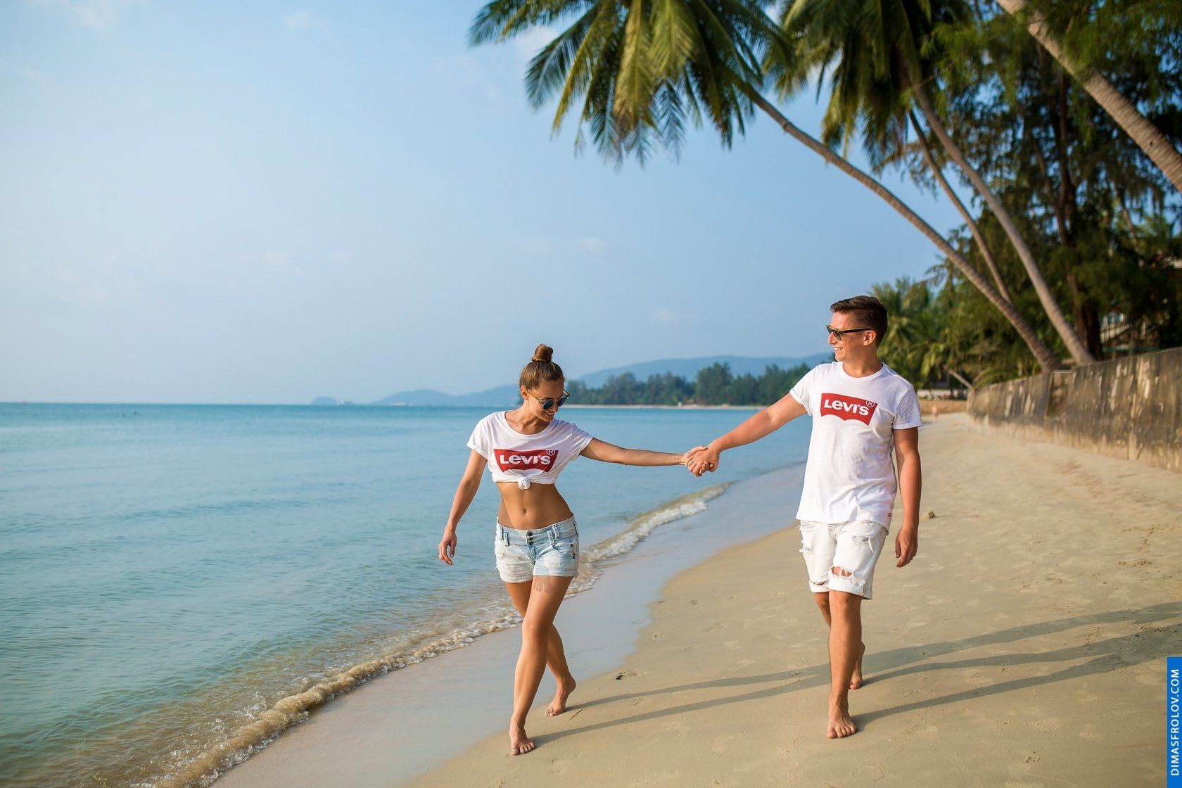 Couple in matching t-shirts having fun together during beach walk