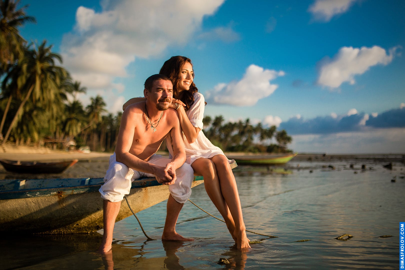 Peaceful couple moment at sunset with a boat in the background and calm shoreline