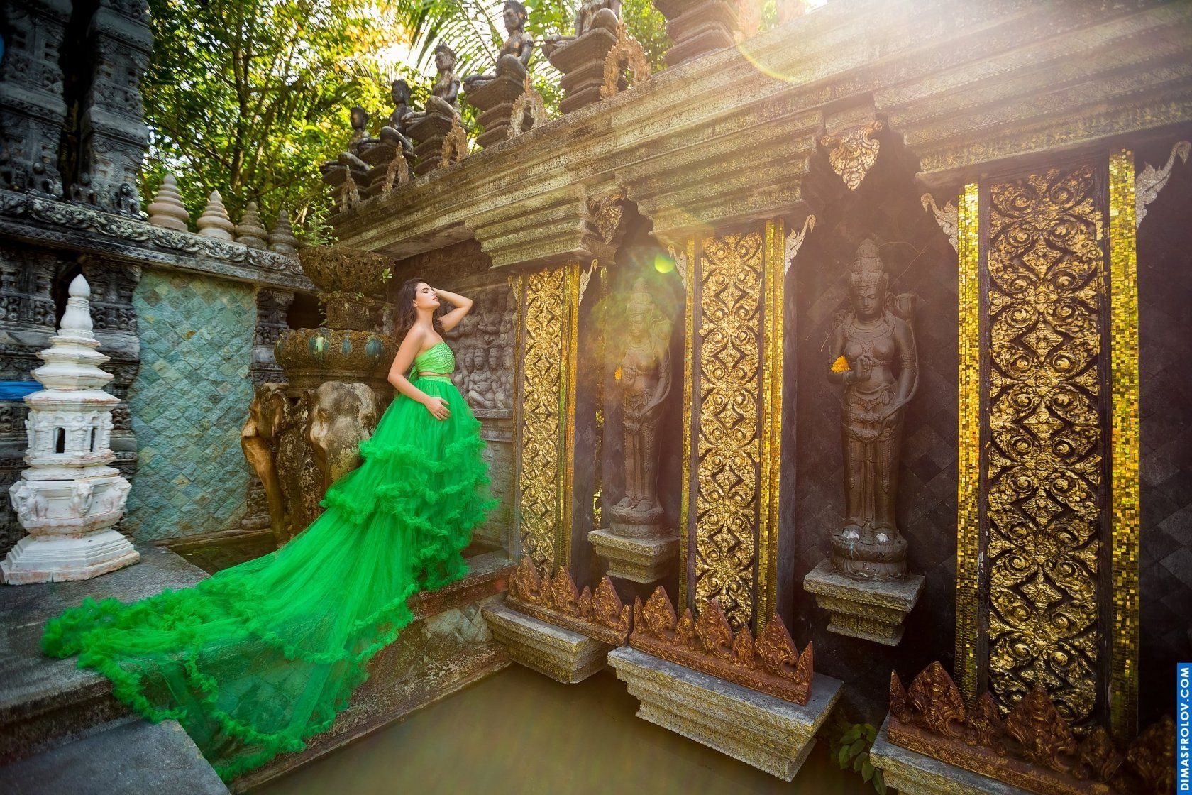 Fantasy-style photo shoot of a woman in emerald gown at ancient temple location