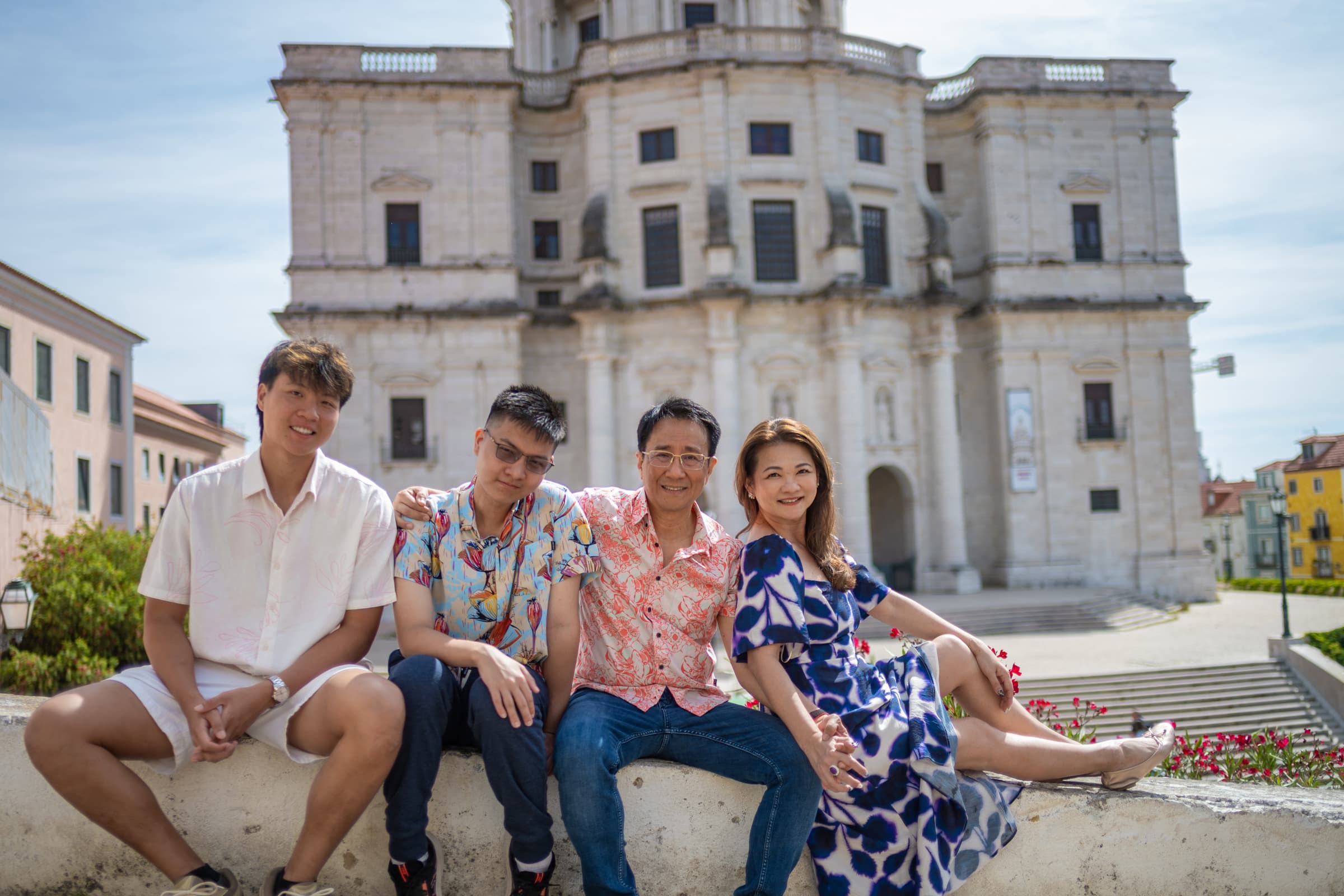 Family with adult sons sitting in front of the National Pantheon, family photoshoot in Alfama, Lisbon