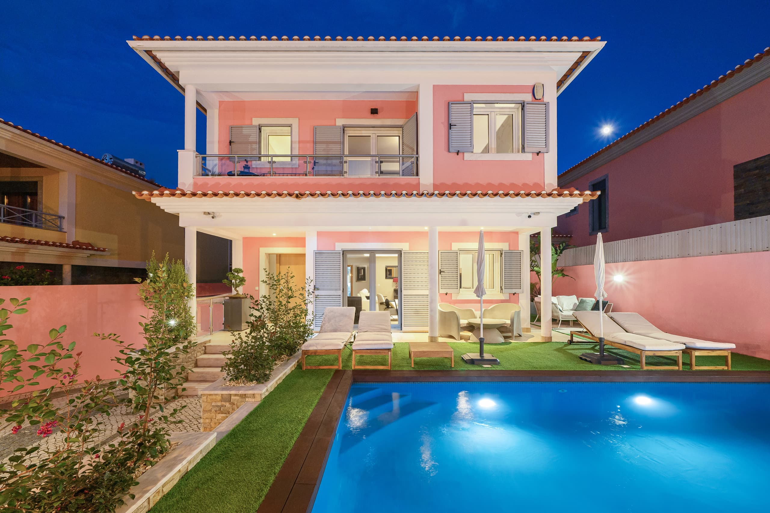 A two-storey house with a pool in Cascais, shot at blue hour