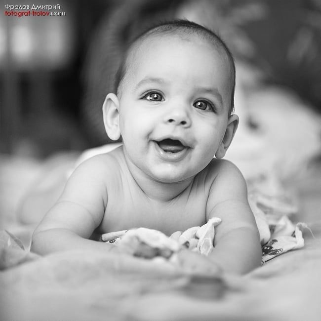 Black-and-white baby portrait — big smile and bright expressive eyes