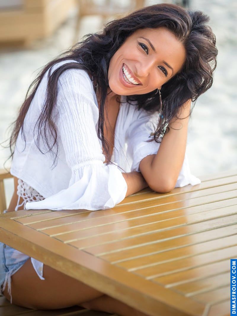 Natural smile of a woman in a casual white beach outfit