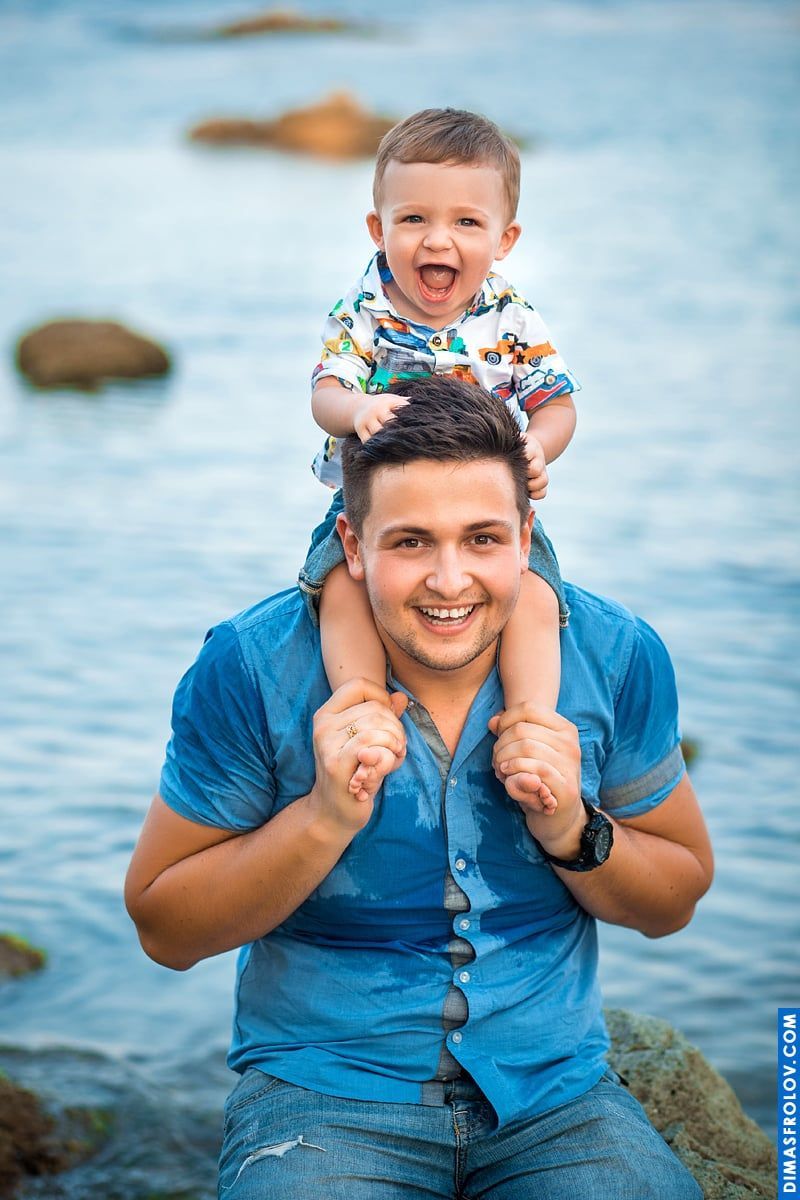 Father and son portrait — both smiling with joy by the sea