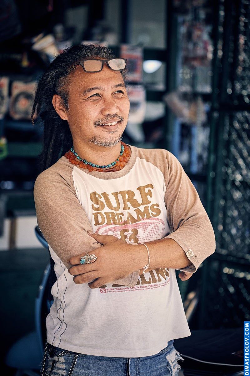 A tropical portrait: a man in a surf shirt stands with arms crossed during a relaxed photo shoot